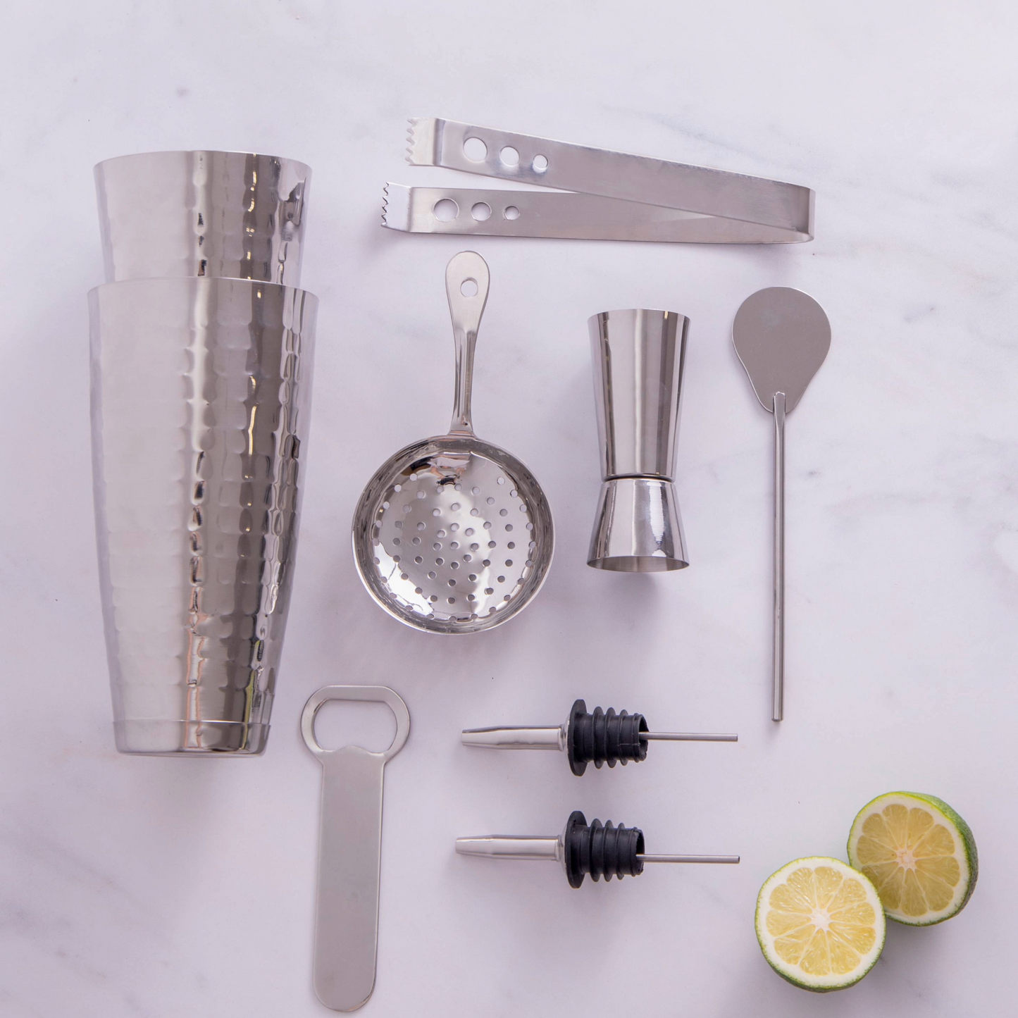 Moderne cocktailset van roestvrij staal met geslagen afwerking, aantrekkelijk gepresenteerd voor lifestyle-shoppers en interieurliefhebbers. Bestel nu bij Sherlocks Place