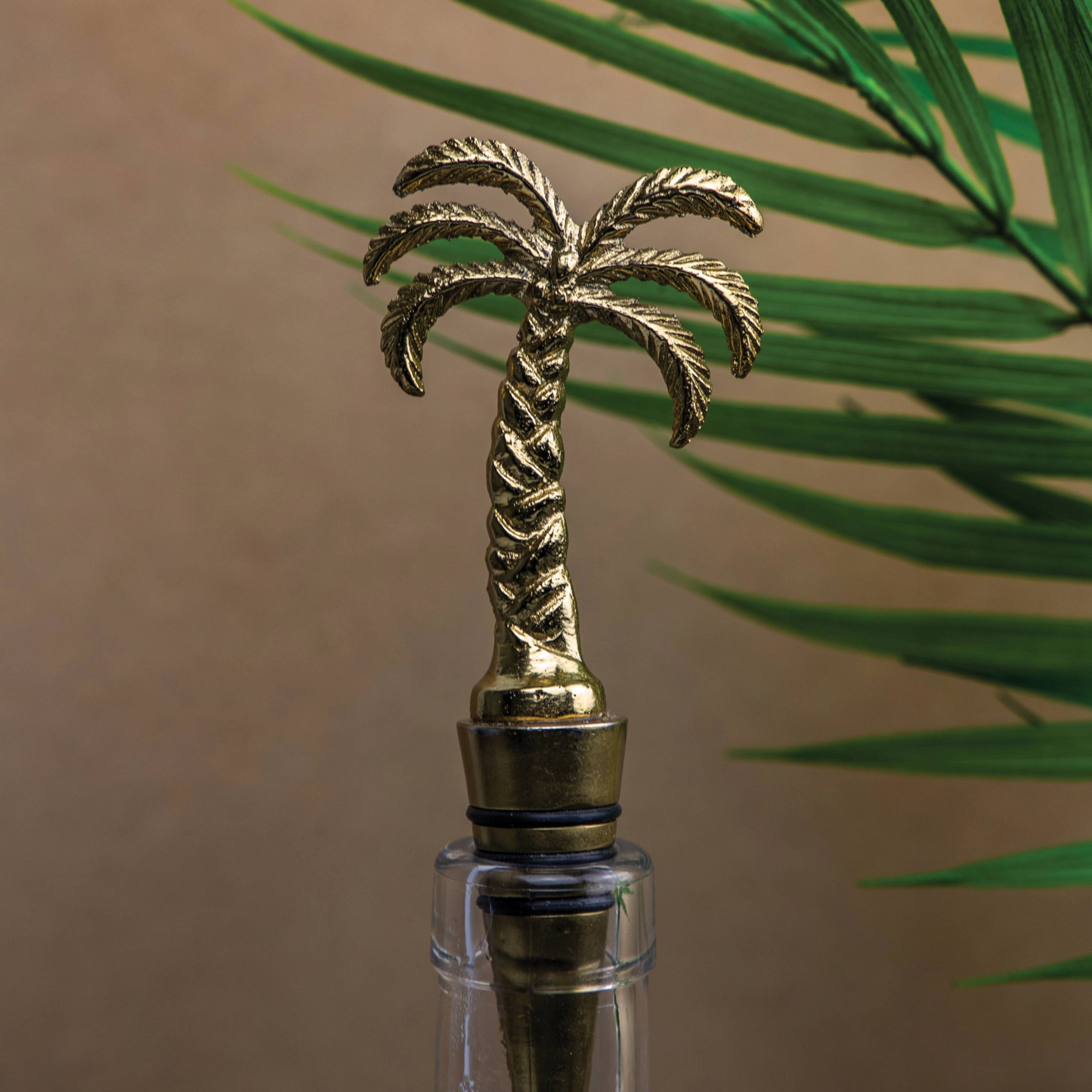 Close-up van de palmboom-flessenstop met tropische achtergrond – een perfecte combinatie van functionaliteit en esthetiek voor interieur- en tafeldecoratie-liefhebbers – verkrijgbaar bij Sherlocks Place.