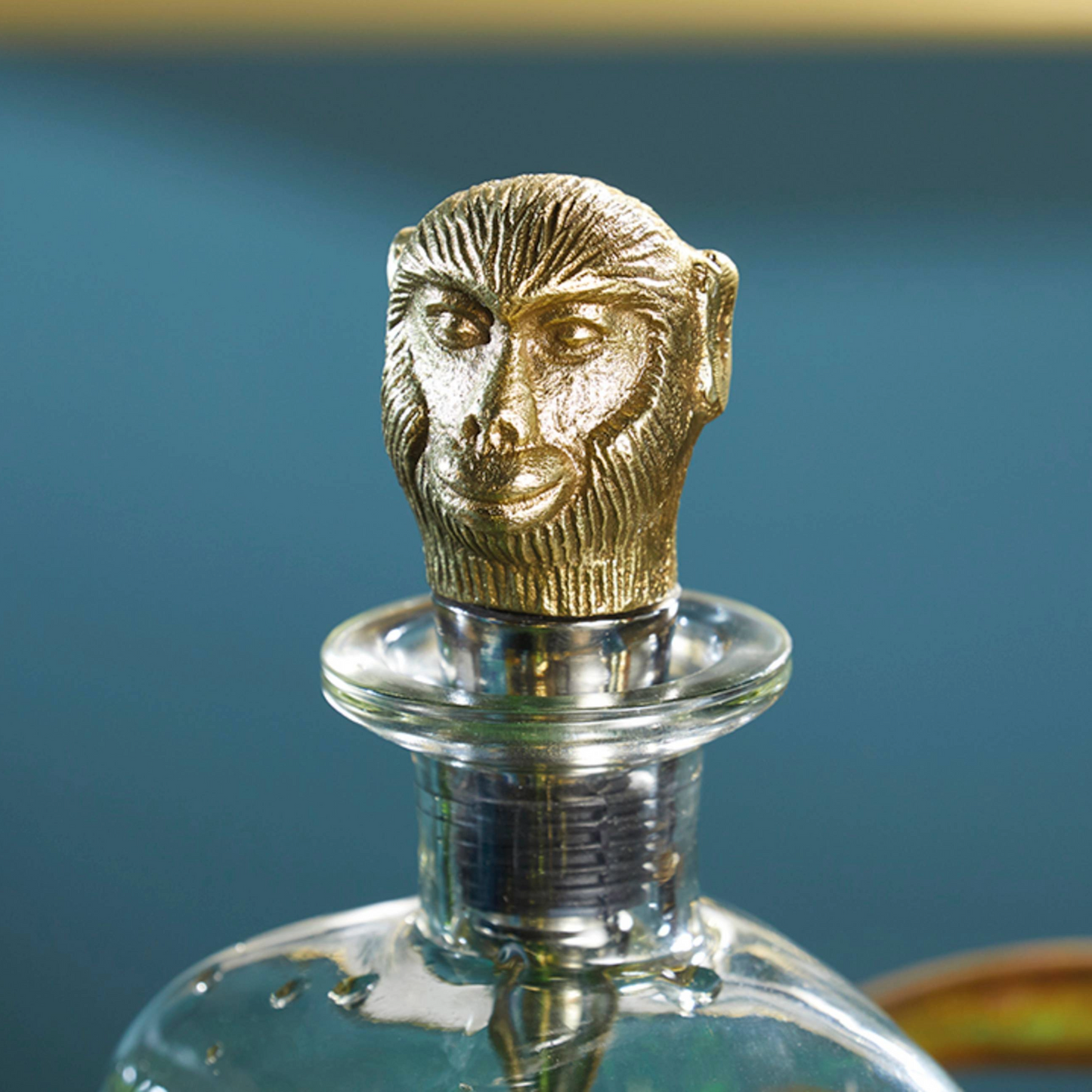 (close-up van de aapkop-stopper):
Gedetailleerde gouden aapkop als luxe finishing touch op deze unieke glazen karaf – een speelse knipoog in een elegant design. Verkrijgbaar bij Sherlocks Place.