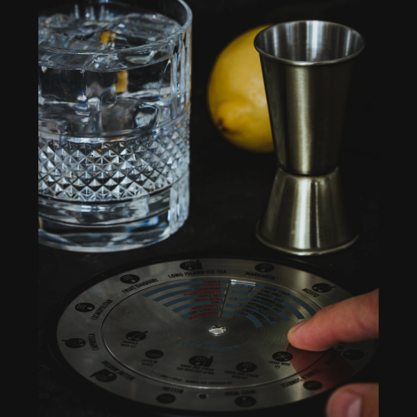 Gebruiker bedient de BarCraft Cocktail Compass naast glas en jigger op donkere ondergrond – Verkrijgbaar bij Sherlocks Place