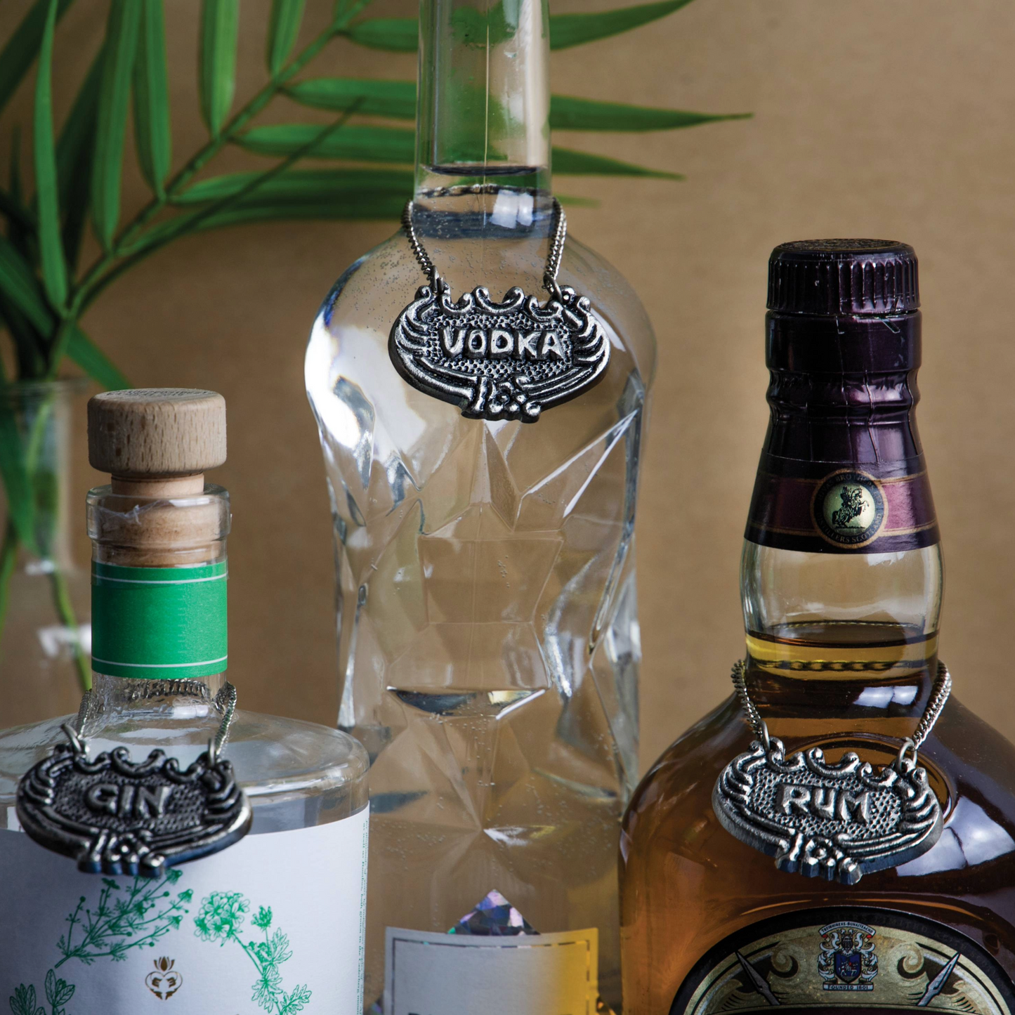 BarCraft metalen decanteerlabels voor gin, rum en vodka aan flessen bevestigd, sfeervolle baropstelling. Verkrijgbaar bij Sherlocks Place