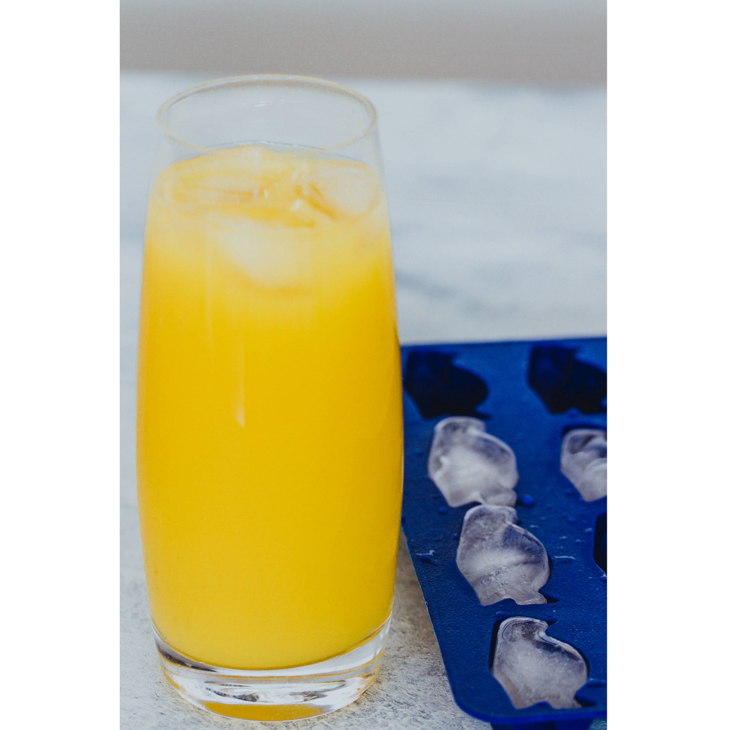 Glas met frisdrank en pinguïnijsblokjes op tafel – een speels detail voor feestelijke gelegenheden. Verkrijgbaar bij Sherlocks Place.