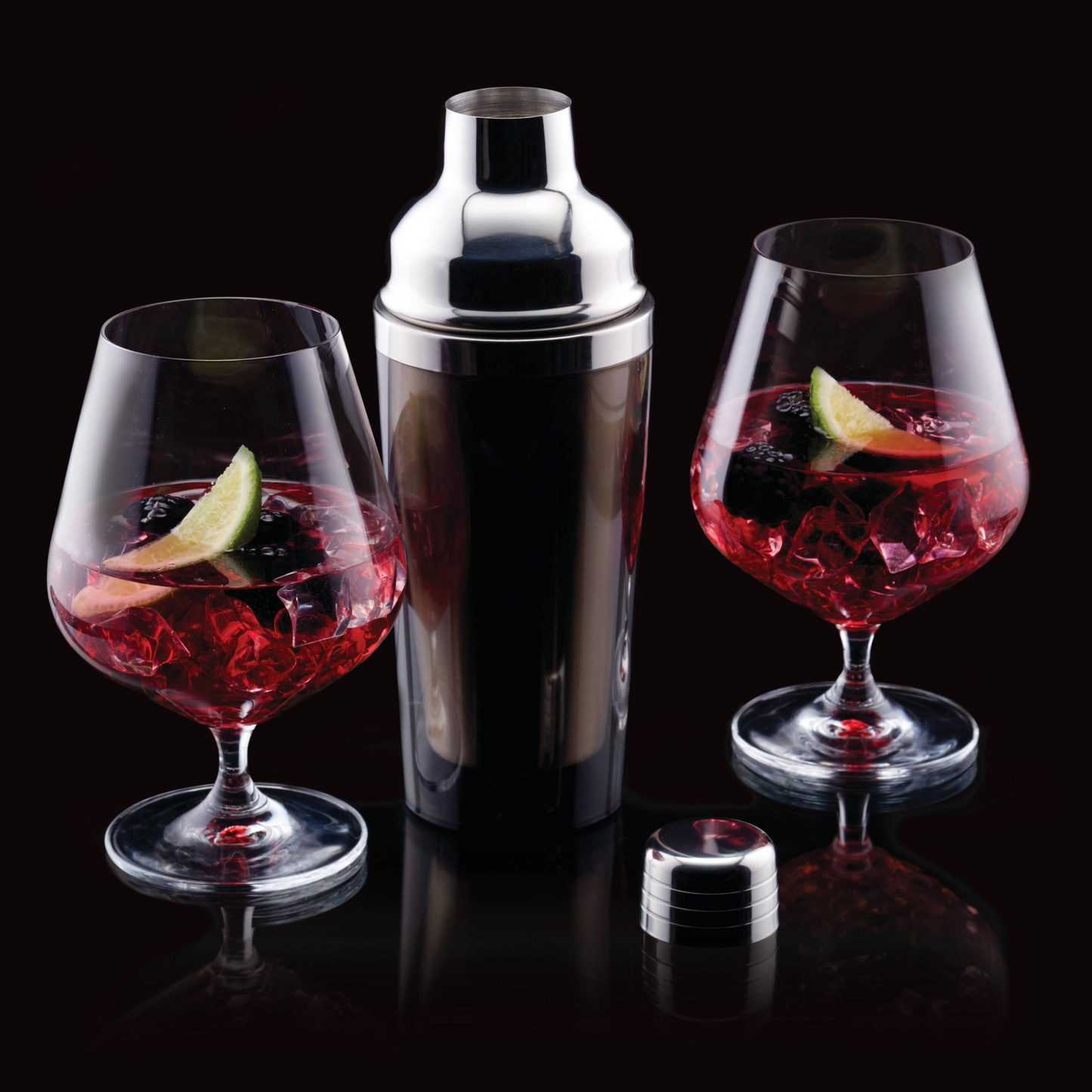 BarCraft Gin Cocktail Gift Set in gebruik met twee gin-tonic glazen gevuld met een rode cocktail, geserveerd met limoen en bessen – perfect voor thuis entertainen en stijlvolle cocktailavonden. Verkrijgbaar bij Sherlocks Place.