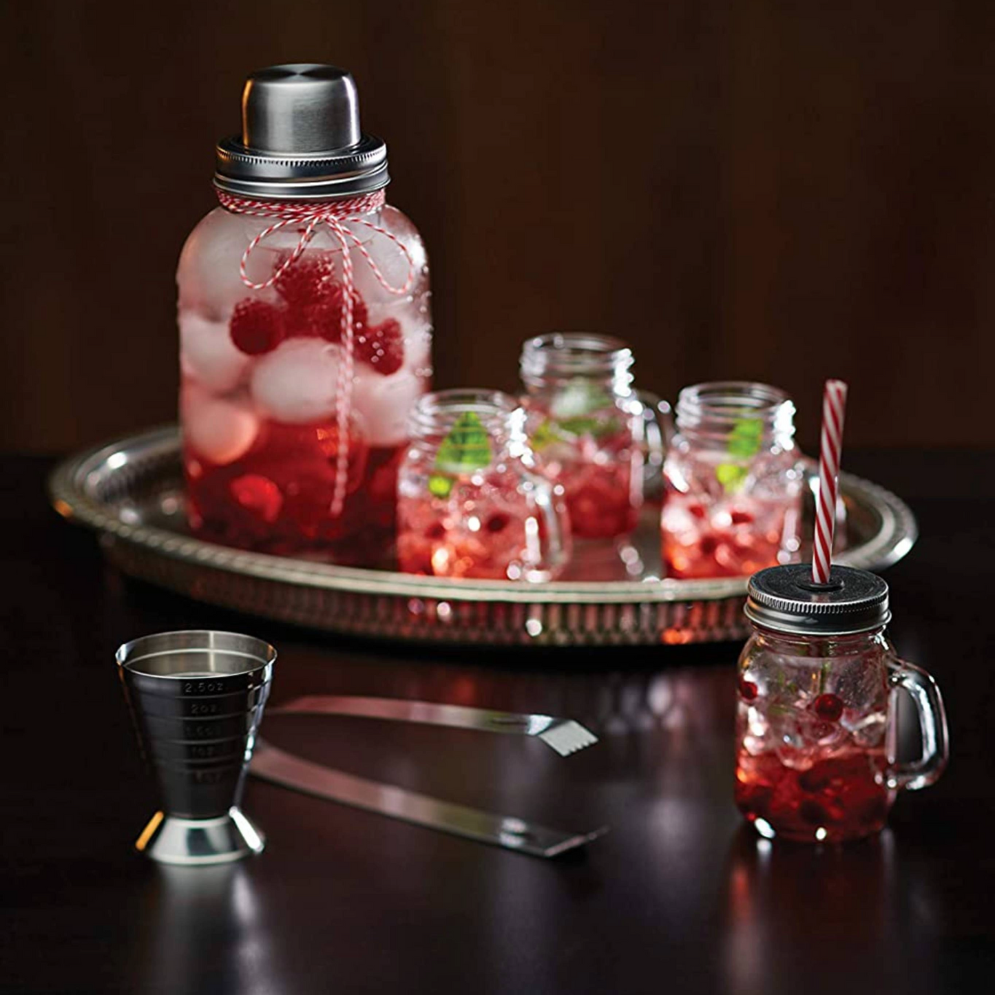RVS cocktail jigger in sfeervolle setting met fruitige cocktail en serveerset – perfect voor feestjes, Monin-liefhebbers en als cadeau. Verkrijgbaar bij Sherlocks Place.