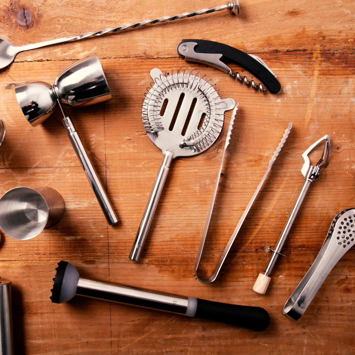 Cocktailtools op houten ondergrond, inclusief ijstang van BarCraft, perfect voor de homebar – verkrijgbaar bij Sherlocks Place.