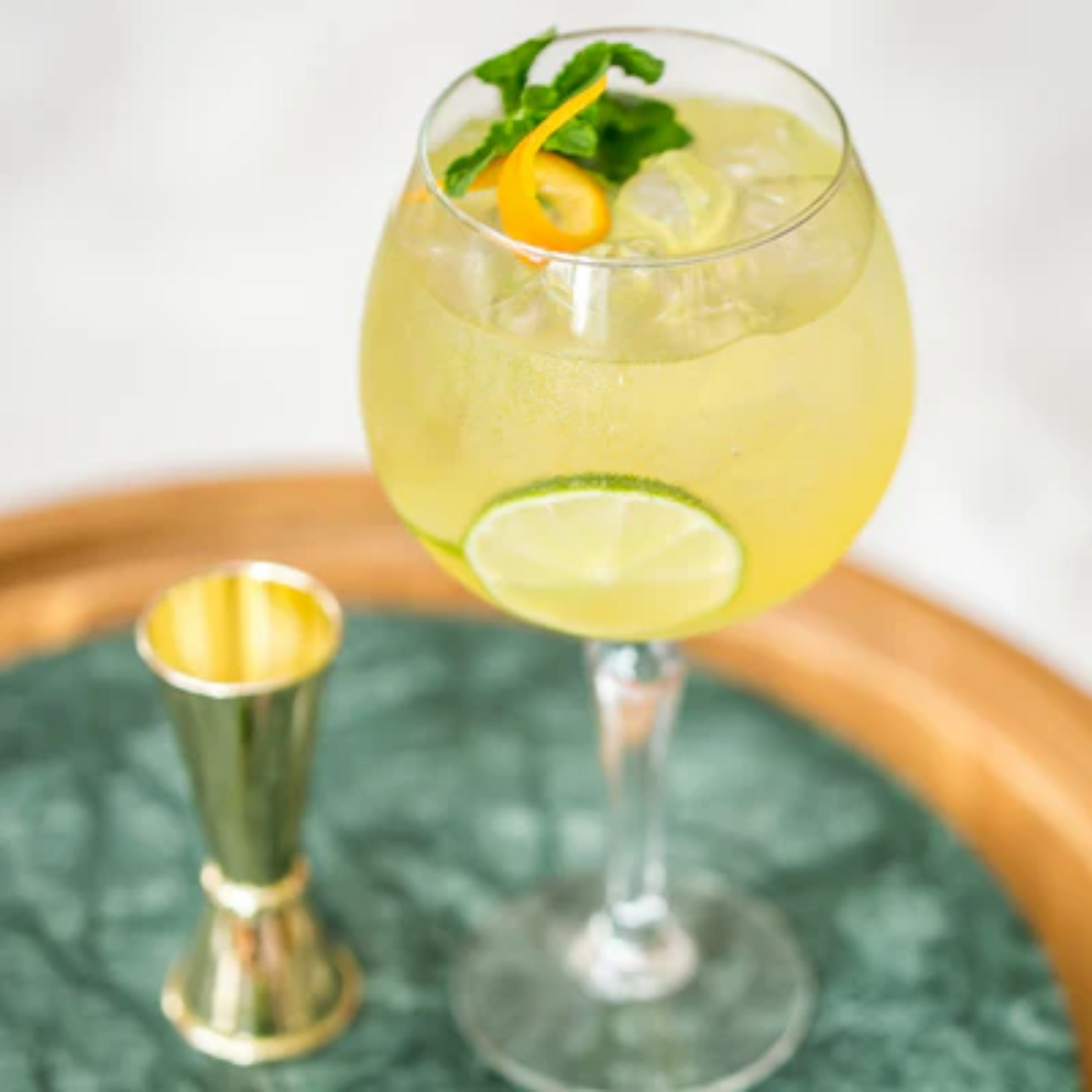 Verfrissende jasmijnspritzer met MONIN Jasmijn siroop, geserveerd met limoen, munt en sinaasappelschil – ideaal voor zomerse cocktails en mocktails met een Aziatische twist. Verkrijgbaar bij Sherlocks Place Rotterdam