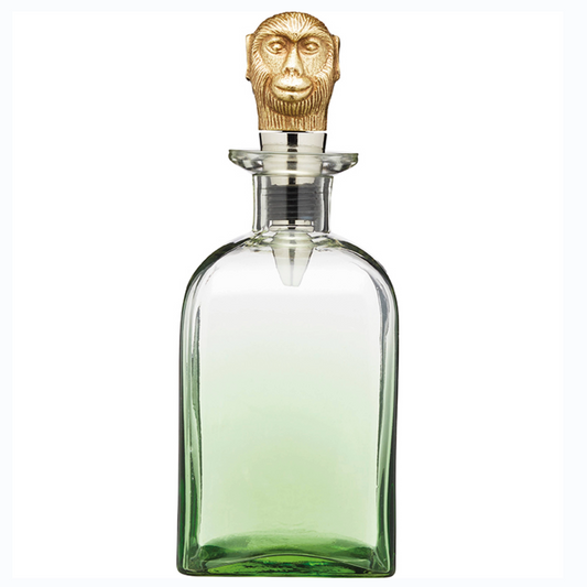 Stijlvolle tropische glazen karaf met groene ombré-kleur en unieke gouden aapkop-stopper – een eyecatcher voor elke thuisbar. Verkrijgbaar bij Sherlocks Place.
