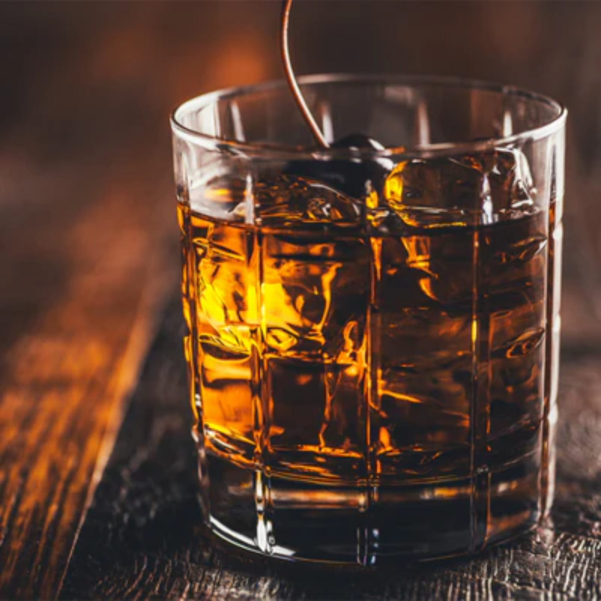 Mooie retro foto van een glas Old Fashioned cocktail op een houten tafel gemaakt met onder andere Monin siropen. Foto in bruintinten. Monin Verkrijgbaar bij Sherlocks Place Rotterdam 