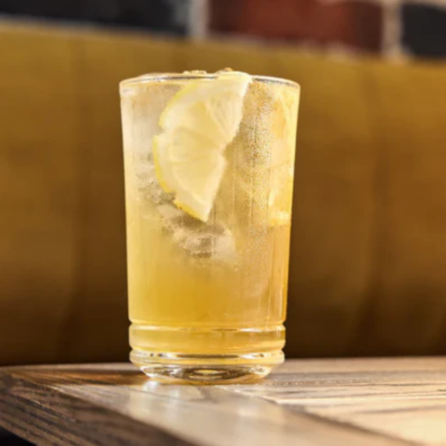 Close-up foto van een Virgin Falernum Rum Mule by Monin. Transparant lemonade glas gevuld met ijsblokjes, Alcoholvrije Caribbean Rum van Monin en Falernum van Monin, gingerbeer en lime juice en een schijfje citroen. Compleet Monin assortiment verkrijgbaar bij Sherlocks Place Rotterdam
